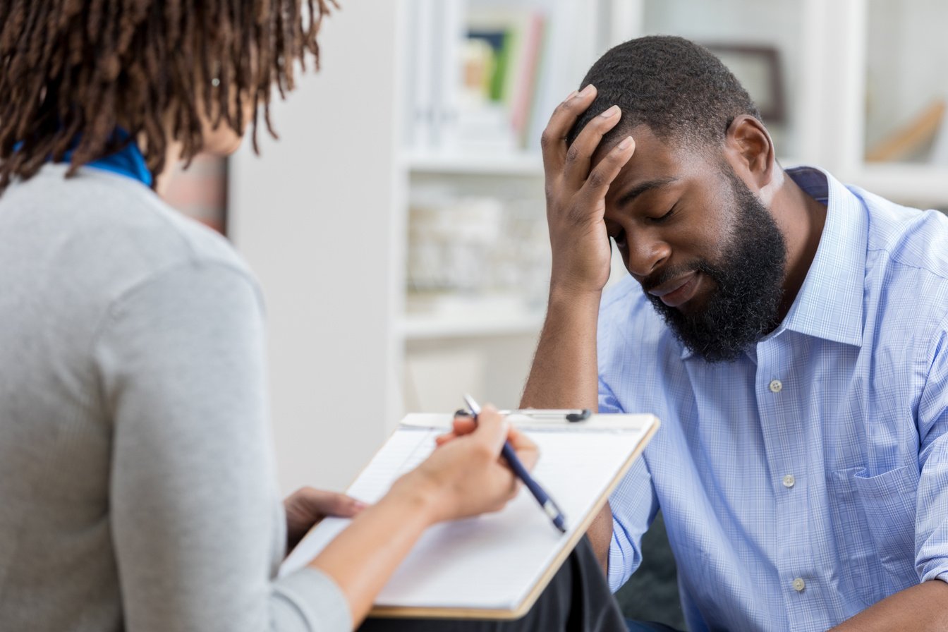 Upset man talks with mental health professional